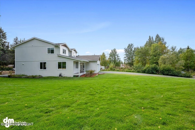 rear view of property featuring a lawn