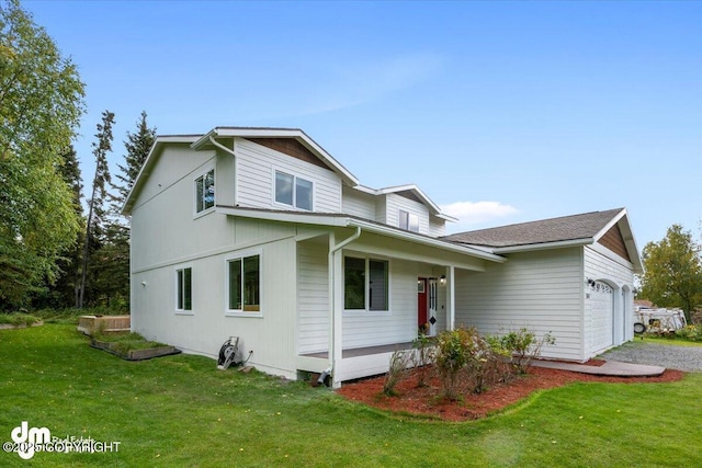 view of front of property with covered porch, an attached garage, and a front yard