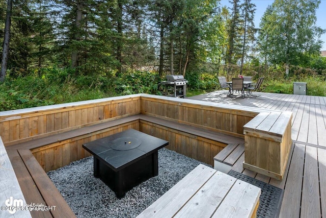 deck with outdoor dining space and area for grilling
