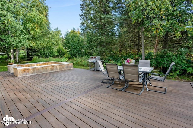 wooden deck with outdoor dining area and a grill