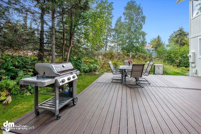deck with outdoor dining space and grilling area