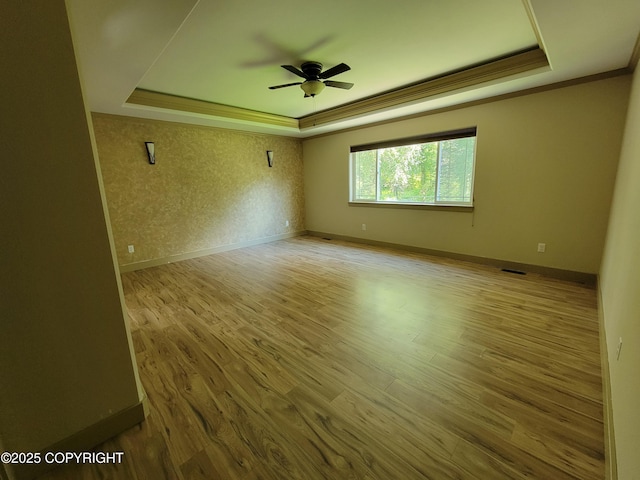 7779 N Showers St, Palmer, AK 99645 - unfurnished room with ceiling fan, visible vents, wood finished floors, a raised ceiling, and ornamental molding