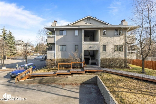 4241 Folker St # D202, Anchorage, AK 99508 - back of house with fence, a balcony, and a chimney