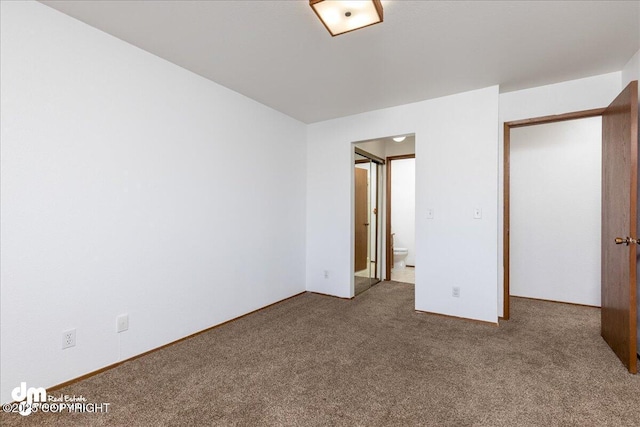 4241 Folker St # D202, Anchorage, AK 99508 - unfurnished bedroom featuring baseboards, ensuite bathroom, and carpet flooring