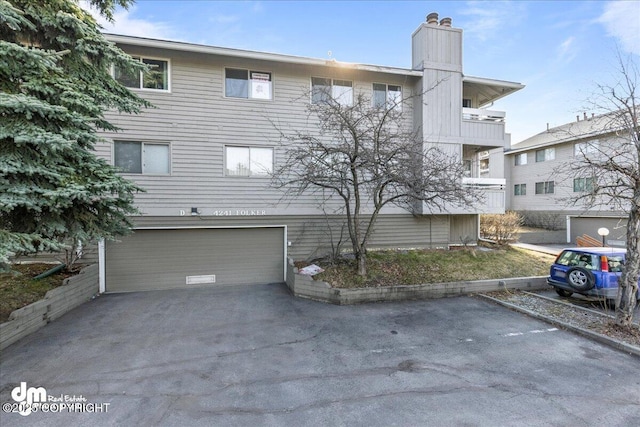 4241 Folker St # D202, Anchorage, AK 99508 - view of front facade with a chimney and a garage