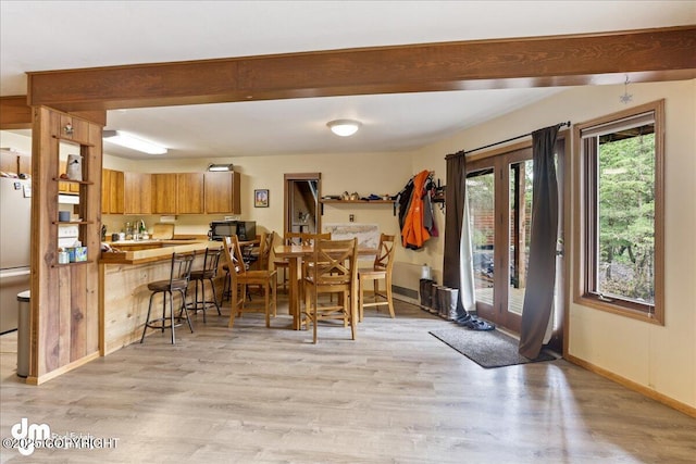 337 Alta Dr, Girdwood, AK 99587 - dining room featuring baseboards, bar, beam ceiling, and light wood-type flooring
