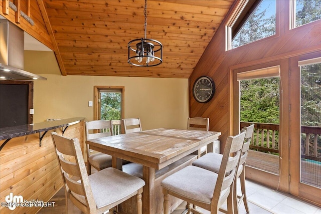 337 Alta Dr, Girdwood, AK 99587 - dining area with wood walls, light tile patterned floors, wooden ceiling, high vaulted ceiling, and an inviting chandelier