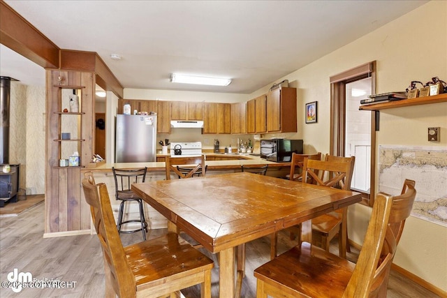 337 Alta Dr, Girdwood, AK 99587 - dining space featuring a wood stove and light wood-style flooring
