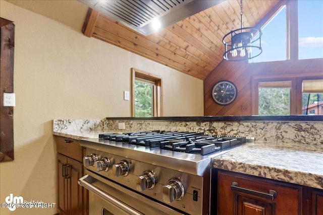 337 Alta Dr, Girdwood, AK 99587 - kitchen with stainless steel stove, a healthy amount of sunlight, vaulted ceiling, and an inviting chandelier