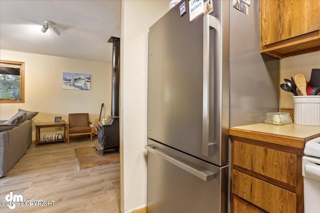 337 Alta Dr, Girdwood, AK 99587 - kitchen featuring brown cabinets, light countertops, freestanding refrigerator, open floor plan, and light wood-type flooring
