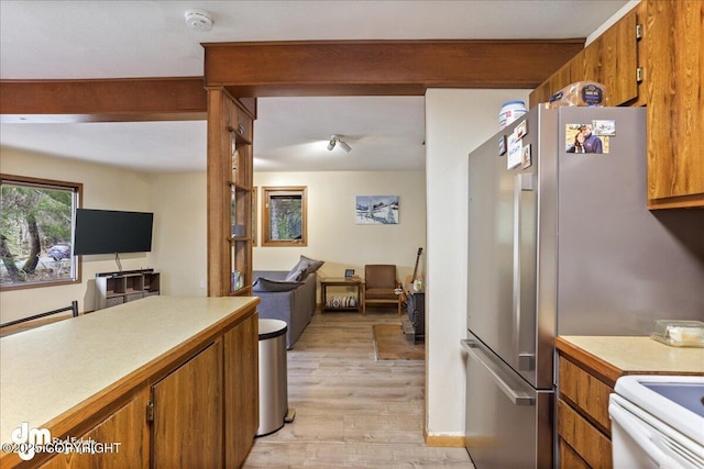 337 Alta Dr, Girdwood, AK 99587 - kitchen featuring light countertops, brown cabinetry, light wood-style flooring, freestanding refrigerator, and open floor plan