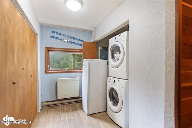337 Alta Dr, Girdwood, AK 99587 - clothes washing area featuring stacked washer and dryer, wallpapered walls, wood finished floors, and laundry area