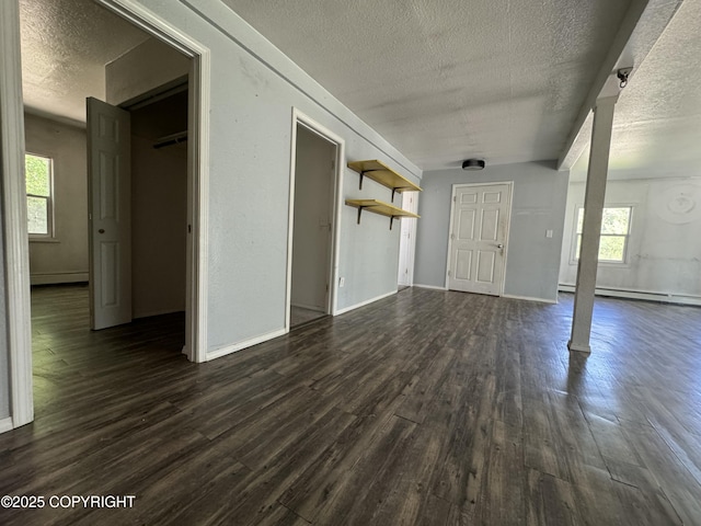 3140 N Brocton Ave, Wasilla, AK 99654 - interior space with plenty of natural light, a baseboard heating unit, a textured ceiling, and dark wood-type flooring