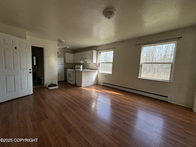 3140 N Brocton Ave, Wasilla, AK 99654 - unfurnished living room featuring a textured ceiling, a baseboard heating unit, and dark wood-style floors