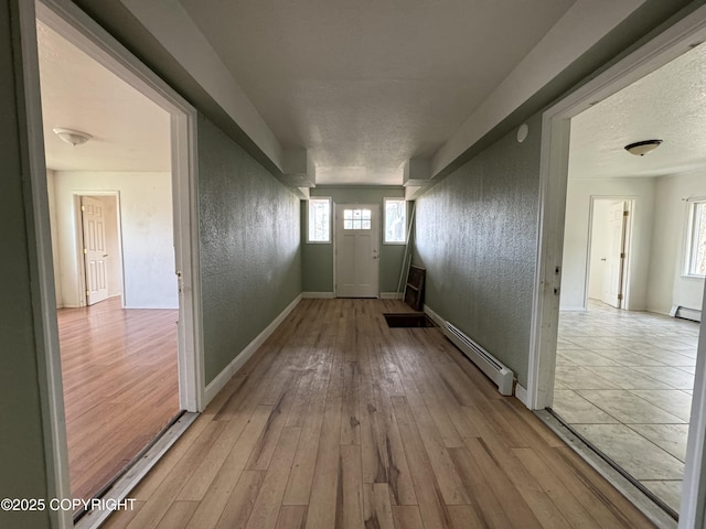 3140 N Brocton Ave, Wasilla, AK 99654 - doorway with plenty of natural light, light wood-style flooring, baseboard heating, and a textured wall