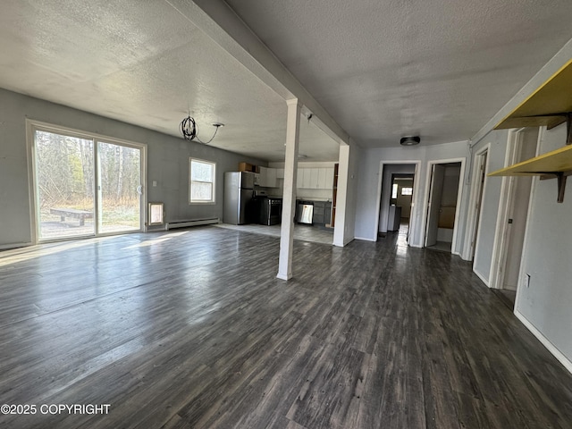3140 N Brocton Ave, Wasilla, AK 99654 - unfurnished living room featuring baseboards, dark wood-style floors, baseboard heating, and a textured ceiling