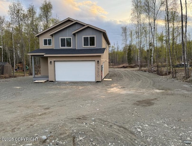 property exterior at dusk featuring an attached garage and driveway