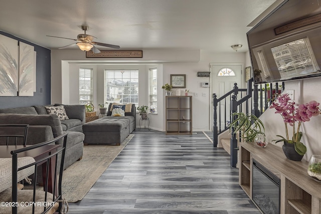 living room with stairway, ceiling fan, and wood finished floors