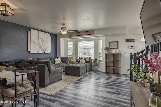 living room with dark wood-type flooring and a ceiling fan