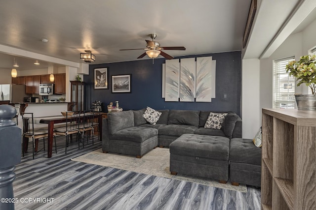 living room with wood finished floors and ceiling fan