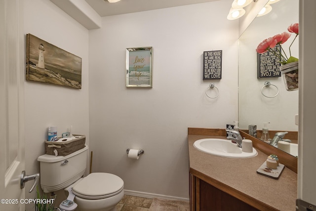 bathroom with toilet, baseboards, and vanity