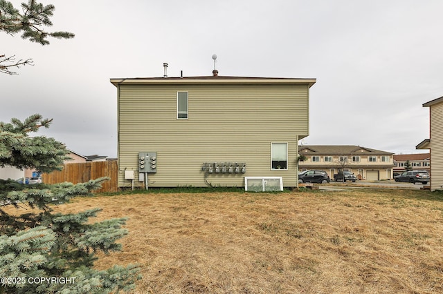 back of property with a yard and fence