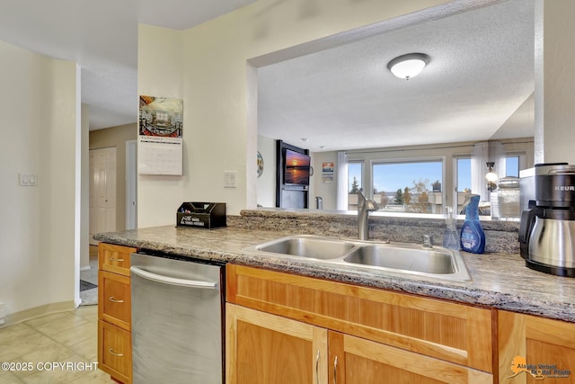 kitchen featuring a sink, a textured ceiling, and dishwasher