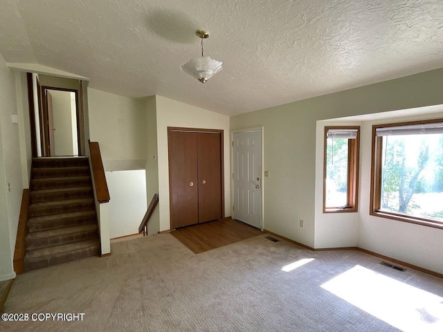 5875 E Alder Cir, Wasilla, AK 99654 - carpeted entryway featuring visible vents, a textured ceiling, and lofted ceiling