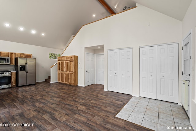 kitchen with brown cabinetry, stainless steel appliances, high vaulted ceiling, dark wood-type flooring, and recessed lighting