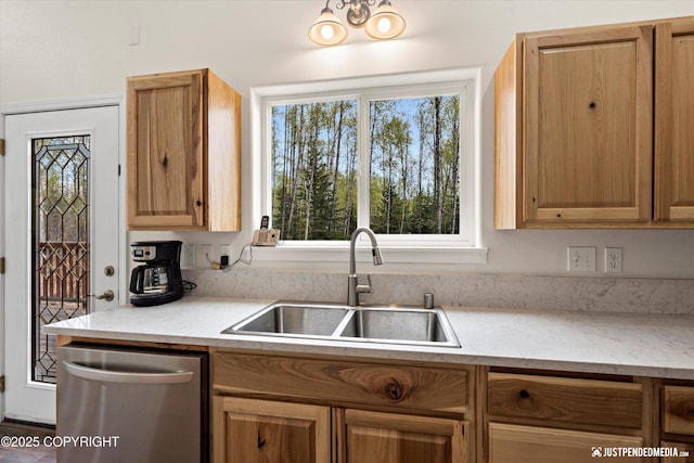 kitchen with a sink, light stone countertops, plenty of natural light, and dishwasher