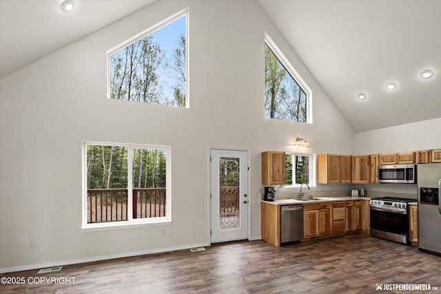 kitchen with a sink, high vaulted ceiling, visible vents, light countertops, and appliances with stainless steel finishes