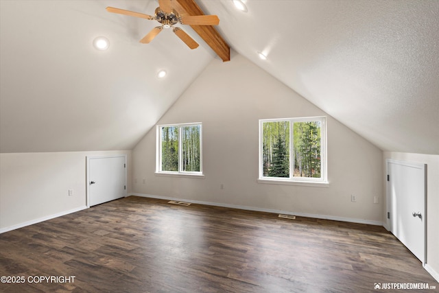 additional living space with visible vents, wood finished floors, a healthy amount of sunlight, and vaulted ceiling with beams