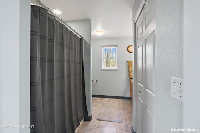 full bath with baseboards, visible vents, and curtained shower