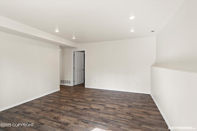 empty room with visible vents, dark wood-style flooring, baseboards, and recessed lighting