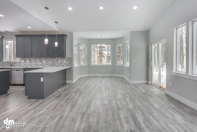 kitchen with light countertops, an inviting chandelier, a healthy amount of sunlight, and dishwasher