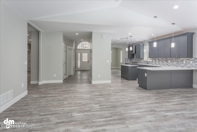 kitchen featuring light countertops, open floor plan, visible vents, and light wood finished floors