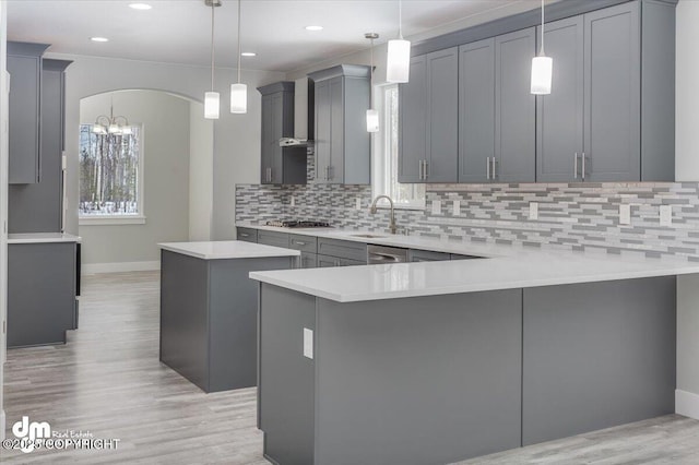 kitchen featuring a kitchen island, baseboards, gray cabinetry, and a sink