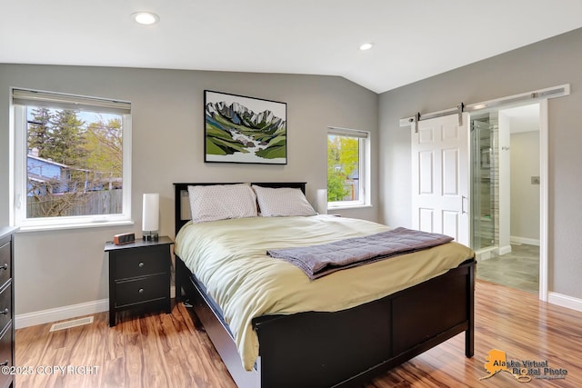 bedroom with a barn door, lofted ceiling, light wood finished floors, baseboards, and recessed lighting