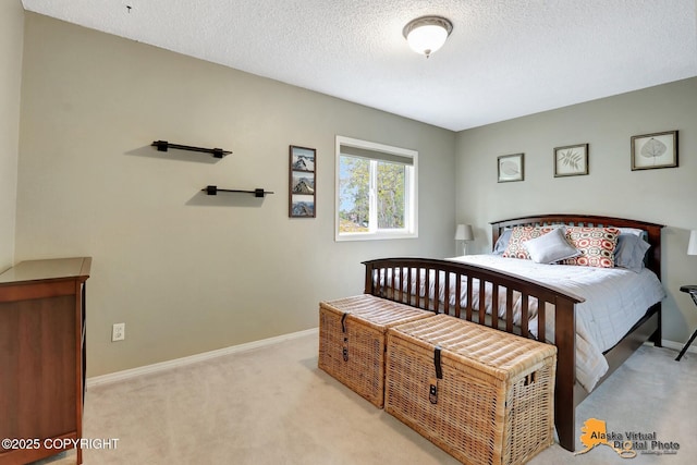 bedroom with light carpet, baseboards, and a textured ceiling
