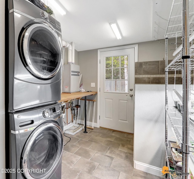 laundry room with estacked washer and dryer and baseboards