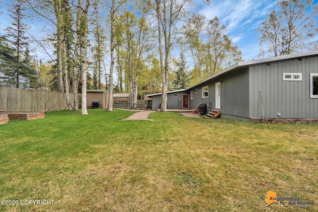 view of yard featuring a storage unit, an outbuilding, entry steps, and a patio area