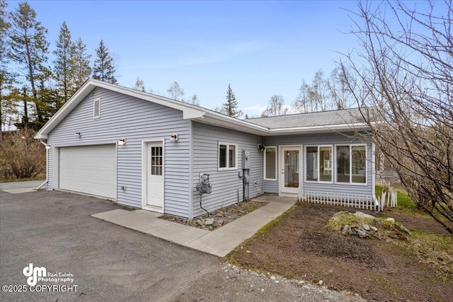 ranch-style house featuring asphalt driveway
