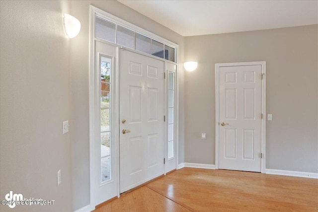 foyer with light wood finished floors and baseboards
