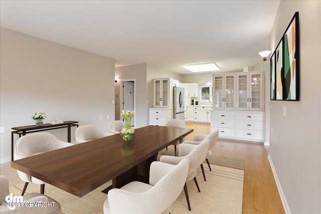 dining room with light wood-style flooring and baseboards