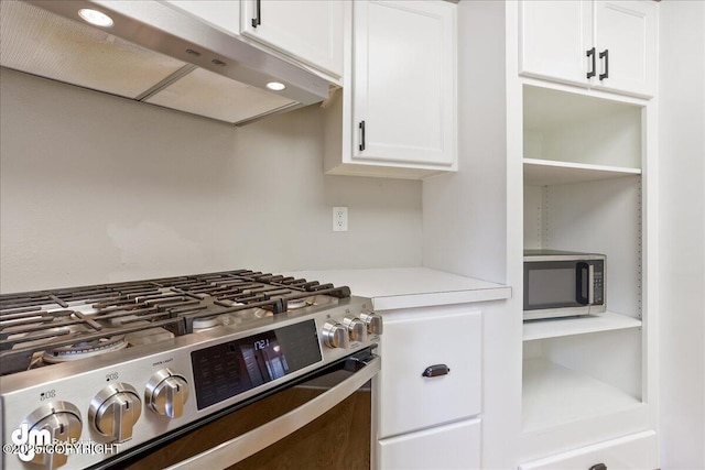 kitchen with appliances with stainless steel finishes, under cabinet range hood, white cabinets, and light countertops