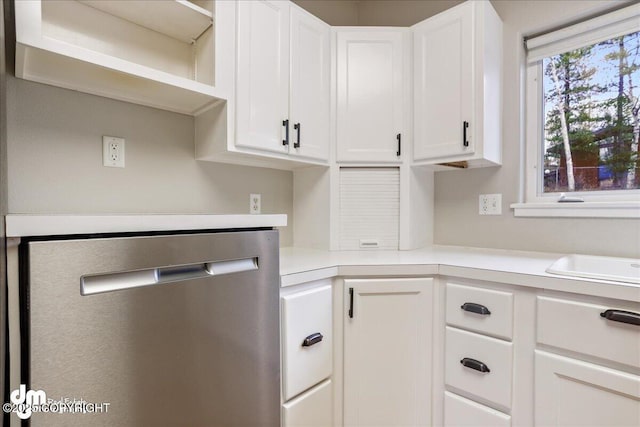 kitchen with stainless steel dishwasher, light countertops, white cabinetry, and open shelves