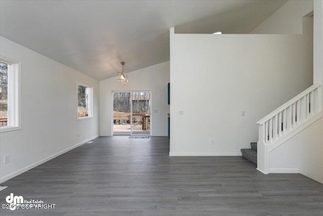 unfurnished living room with plenty of natural light, dark wood-type flooring, lofted ceiling, and stairway