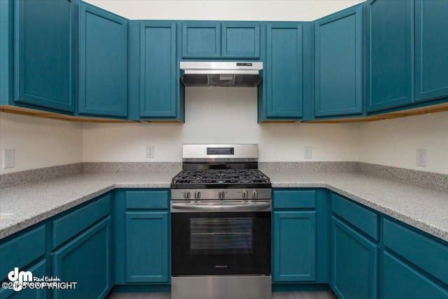kitchen with under cabinet range hood, light countertops, blue cabinetry, and gas range