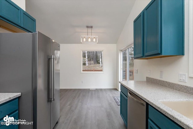 kitchen featuring light wood-style floors, light countertops, stainless steel appliances, baseboards, and blue cabinets