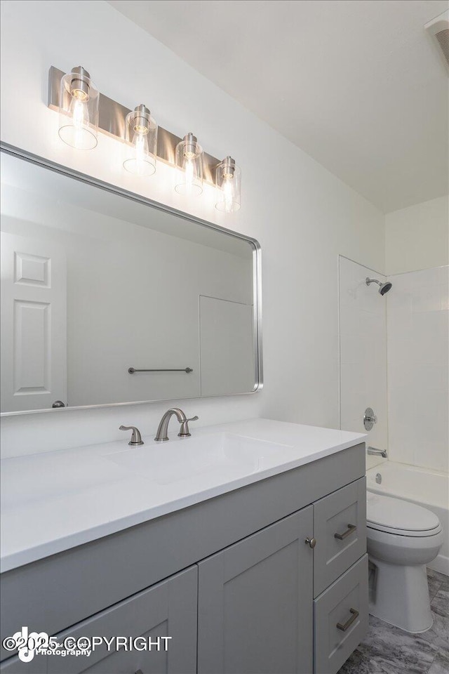 bathroom with vanity, marble finish floor, bathing tub / shower combination, and toilet